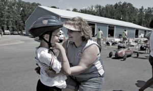 A mother embraces a child after a Soap Box derby race.